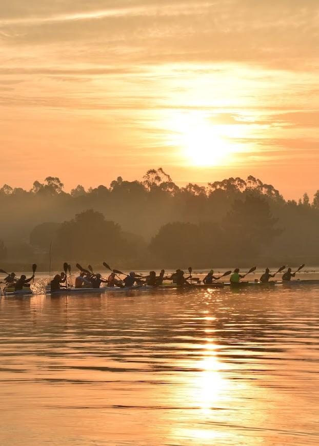 Canoístas na ria ao pôr do sol